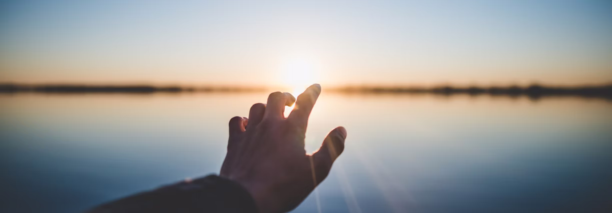 hand reaching out to sun for hope